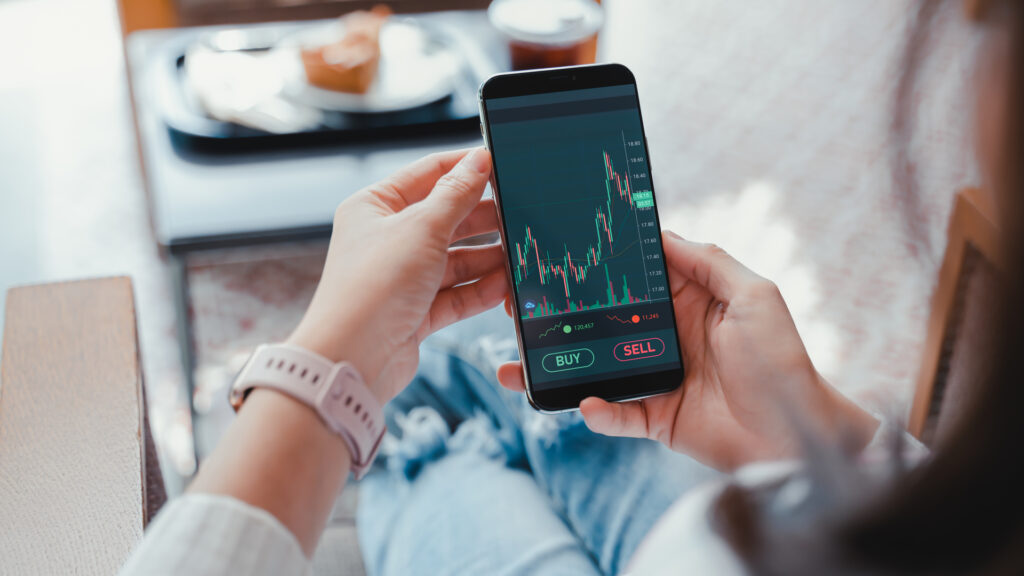 A woman checking investment performance on a phone. 