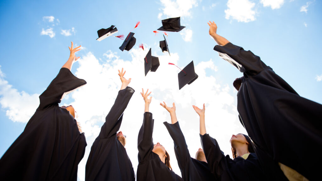 A group of graduates throwing their caps.