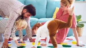 A family with young children playing Twister.