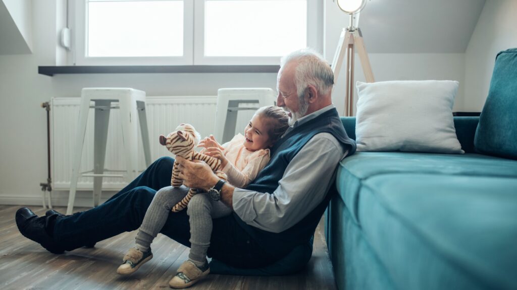 A grandfather playing with his granddaughter.